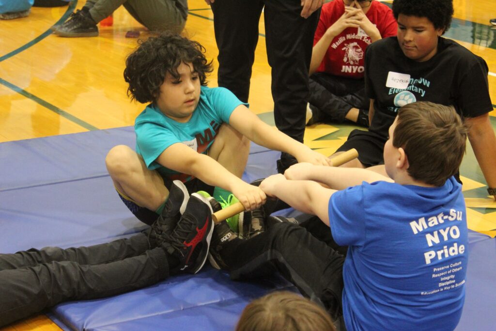 Two Junior NYO athletes play the Eskimo Stick Pull, now known as Inuit Stick Pull.